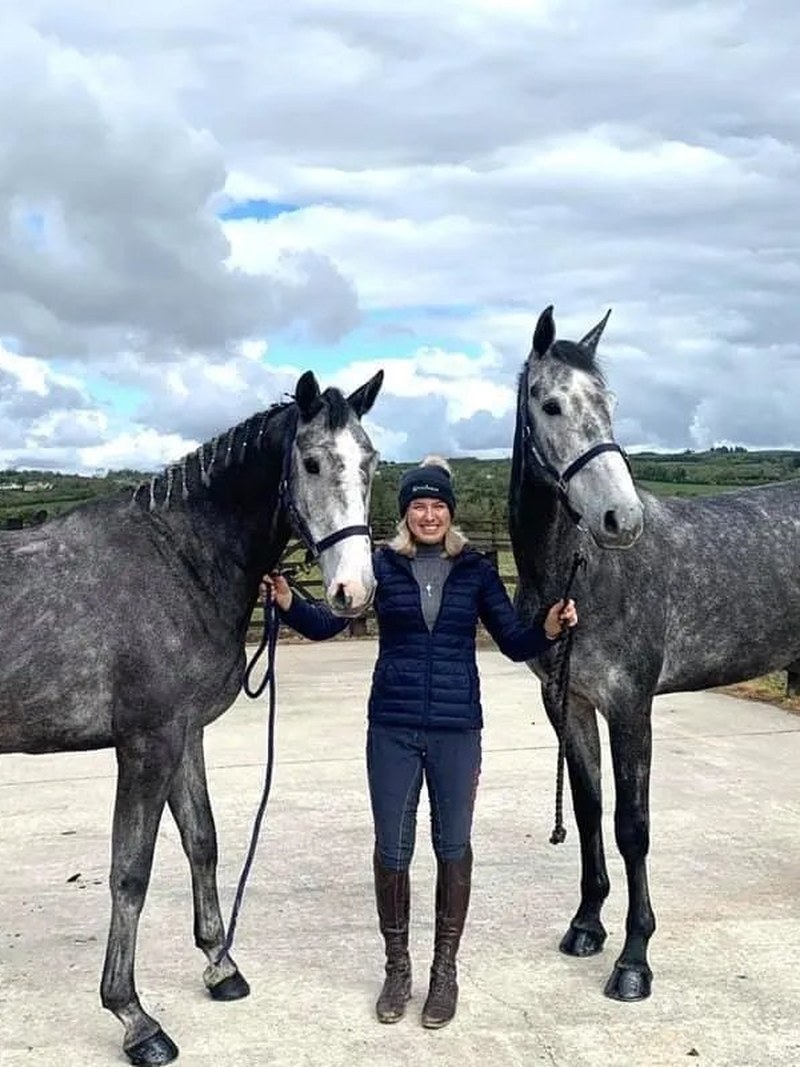 Martha Tomlinson with two grey sport horses in Ireland